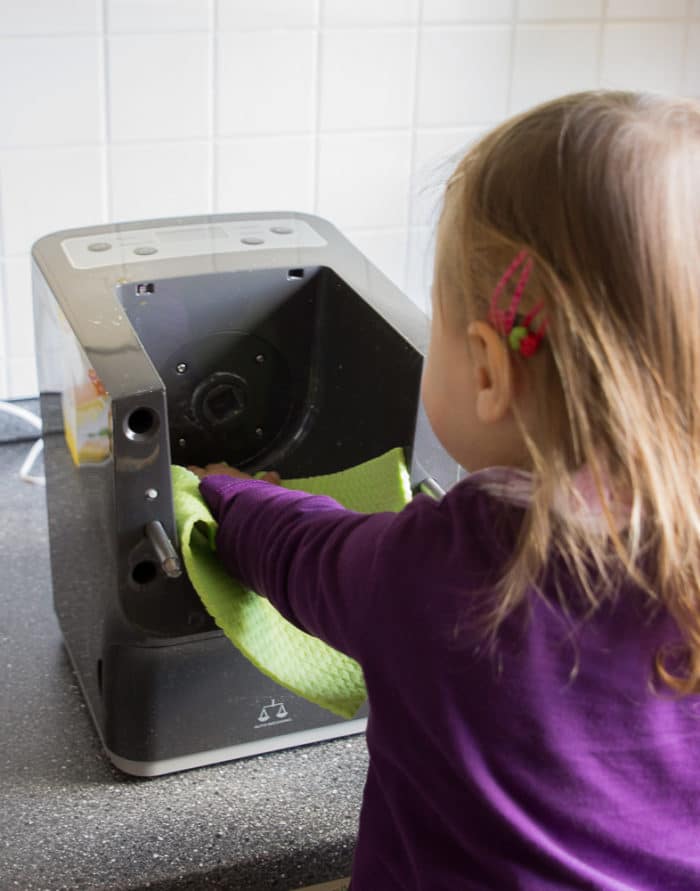 Mädhcne steht auf dem learningtower und hilft beim Nuden selber machen