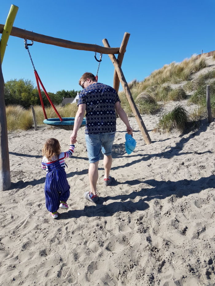 Papa und Mädchen auf dem Spielplatz auf dem Weg zur Schaukel im Landal Strand Resort Ouddorp Duin