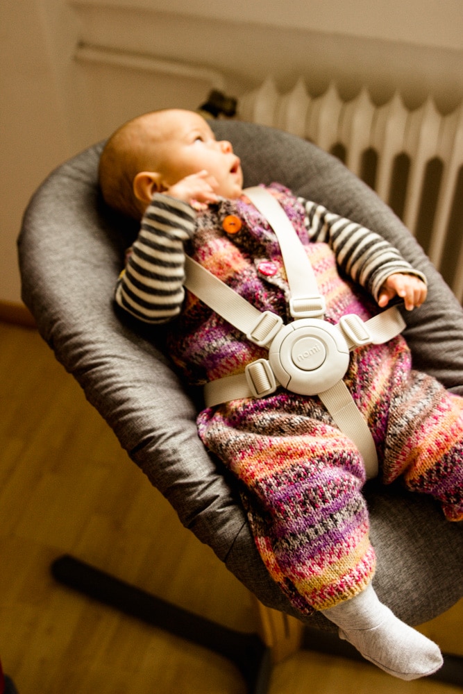 Baby liegt im Nomi Hochstuhl